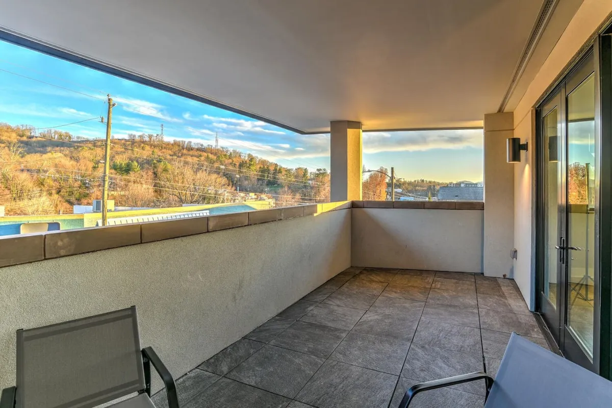 A spacious balcony with comfortable outdoor furniture overlooks a stunning landscape, offering panoramic views of the surrounding area. The setting is tranquil, with plenty of space for relaxing, dining, or simply soaking in the sights. The balcony feels private yet connected, inviting you to enjoy both sunrise and sunset moments.